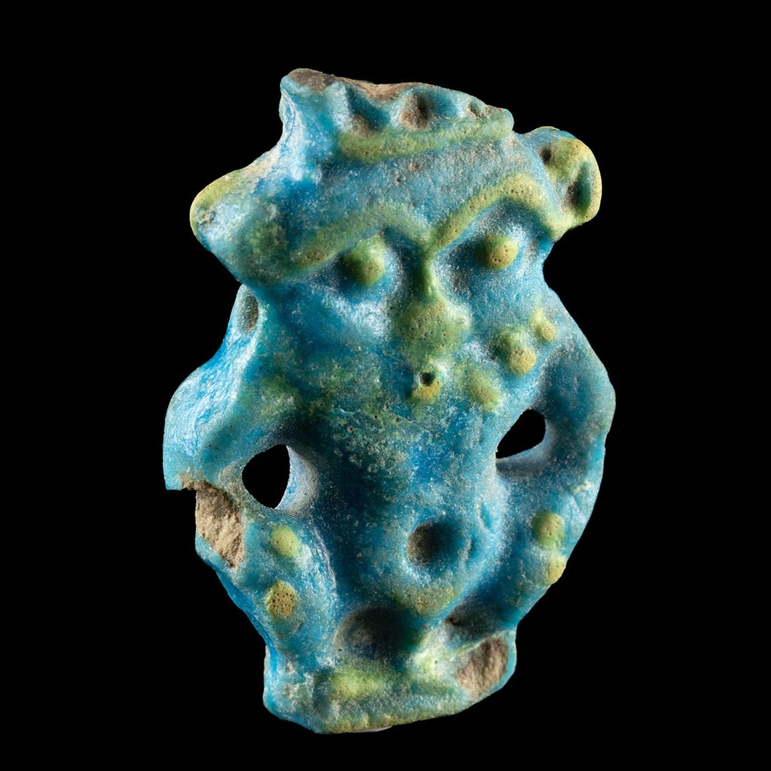 Egyptian Faience Amulet - Bes the Household Protector: North Africa, Egypt, Late Period, ca. 664–332 BCE. A turquoise-glazed faience amulet rendering the leonine dwarf god Bes in his familiar frontal, apotropaic pose. Modeled with a broad grimacing 