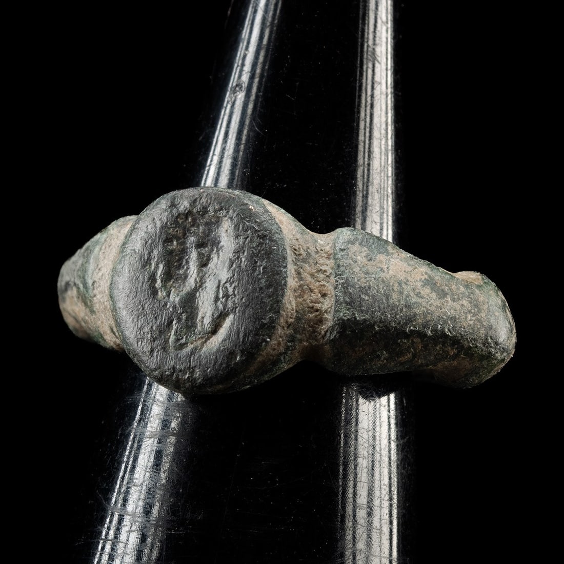 Roman Signet Ring with Male Bust in Profile: Roman, Imperial period, ca. 100–300 CE. A compact cast finger ring whose flattened oval bezel carries a male bust in low relief, shown in profile and facing left, the head set above a suggestion