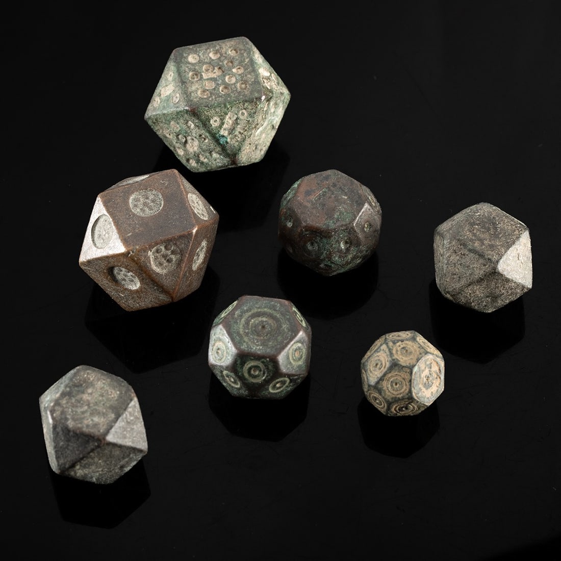 Seven Viking Cubo-Octahedral Trade Weights: Northern Europe, Scandinavia, Viking culture, ca. 800–1050 CE. A group of seven miniature metal weights, most of cubo-octahedral form with square faces truncated by triangular facets, the rest a