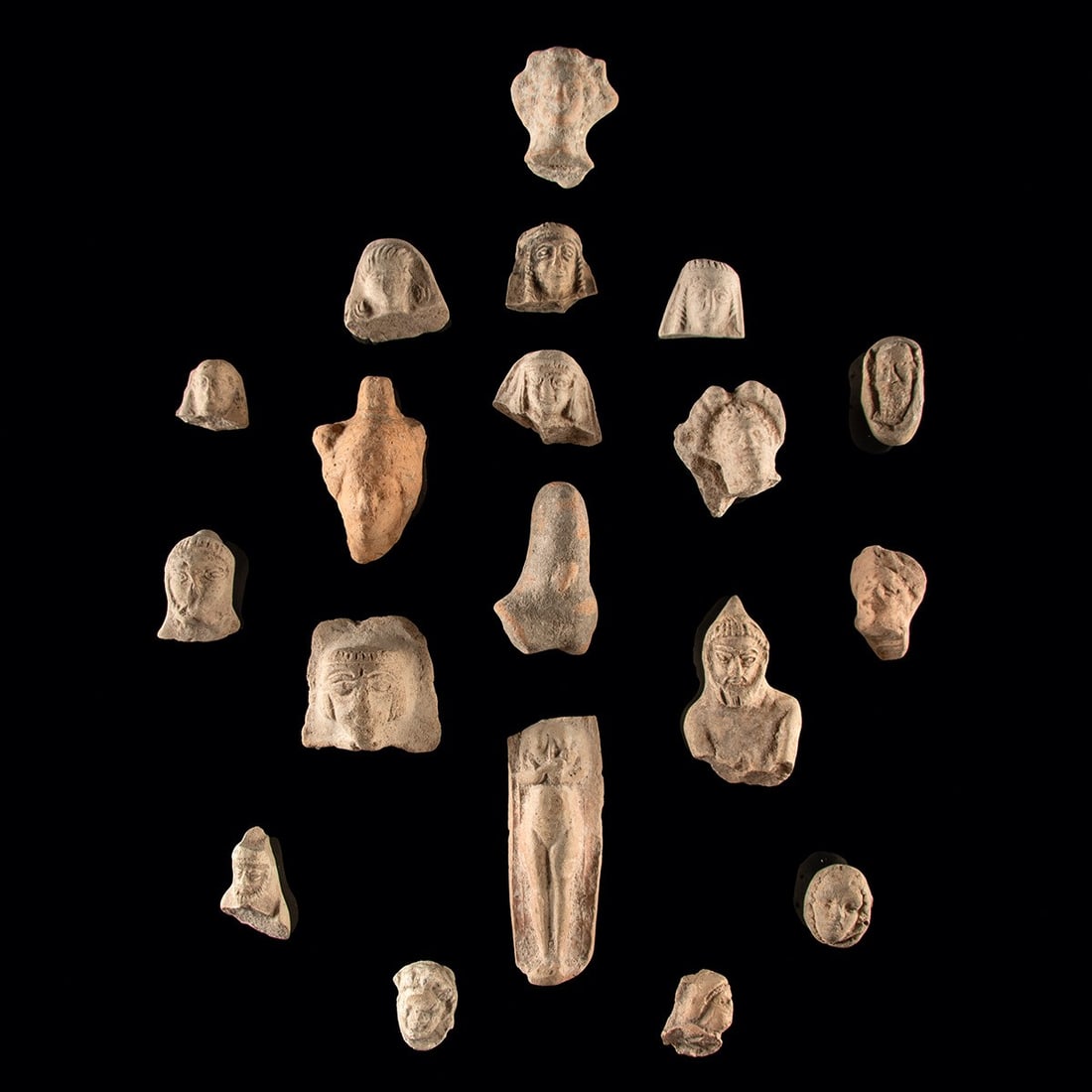 Nineteen Holy Land Pottery Heads/Figures: Near East, Southern Levant, Holy Land, Assyrian to Roman period, ca. 800 BCE – 300 CE. A collection of nineteen pottery figural fragments from the Holy Land, dating from the Assyrian to Roman pe
