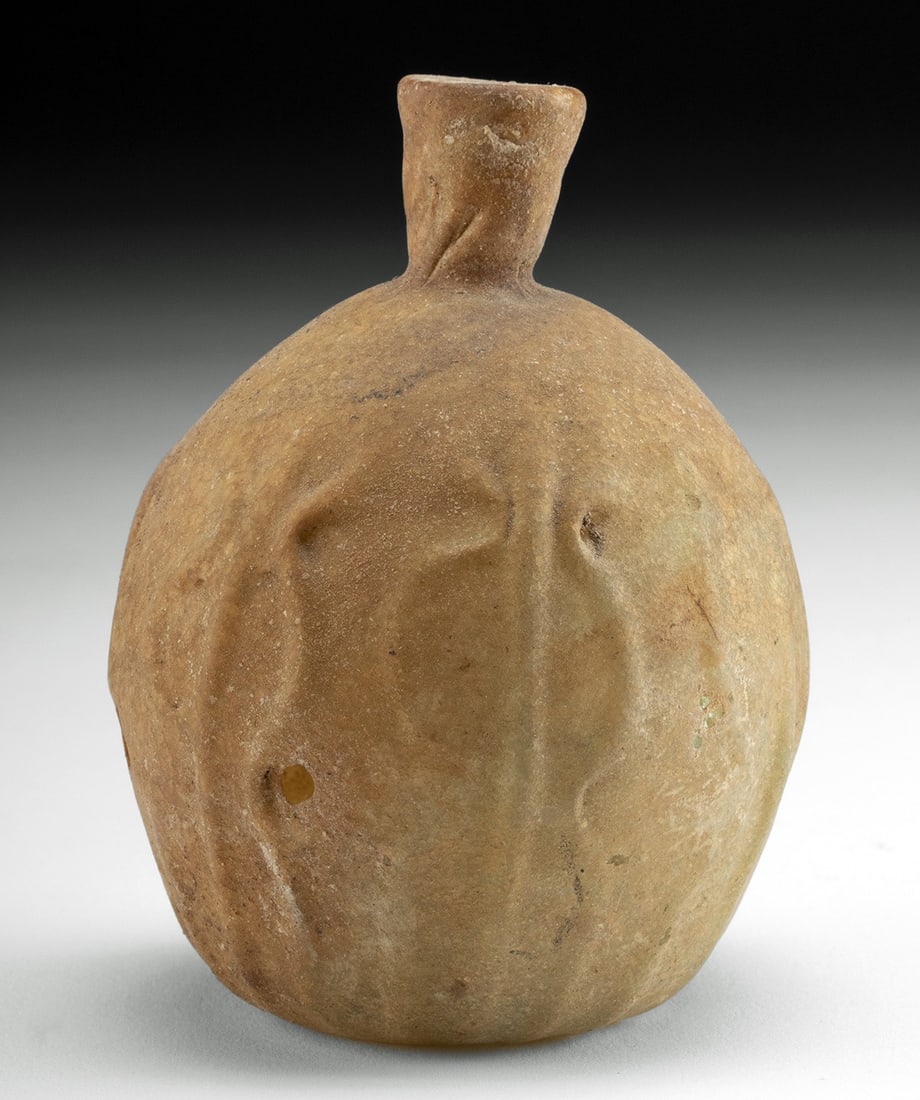 Islamic Yellow Glass Sprinkler Flask: Ca. 300–600 CE. Ancient Near East, Holy Land, Islamic, ca. 4th to 6th century CE. A pattern-molded glass sprinkler flask exuding yellow-green hues. The round vessel features linear motifs raised