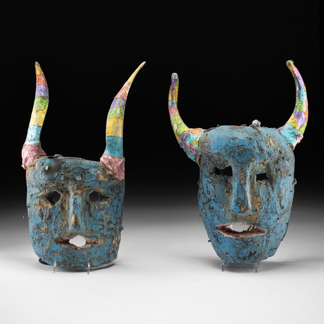 Pair of Mexican / Guatemalan Diablo Dance Masks: Central America, Mexico or Guatemala, Folk Art, ca. 1900–1975 CE. A pair of horned diablo masks carved from softwood, each face washed in cerulean blue over a heavily worked surface of chipped p