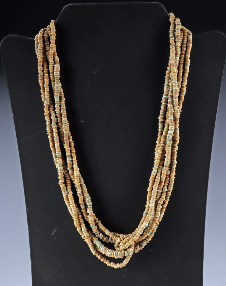 Ancient Egyptian Faience Bead Multi Strand Necklace: Ca. 1550–332 BCE. Egypt, New Kingdom to Late Period, ca. 1550 to 332 BCE. A multi-strand necklace composed of numerous ancient faience disk beads in warm tan hues with scattered pale turquoise t