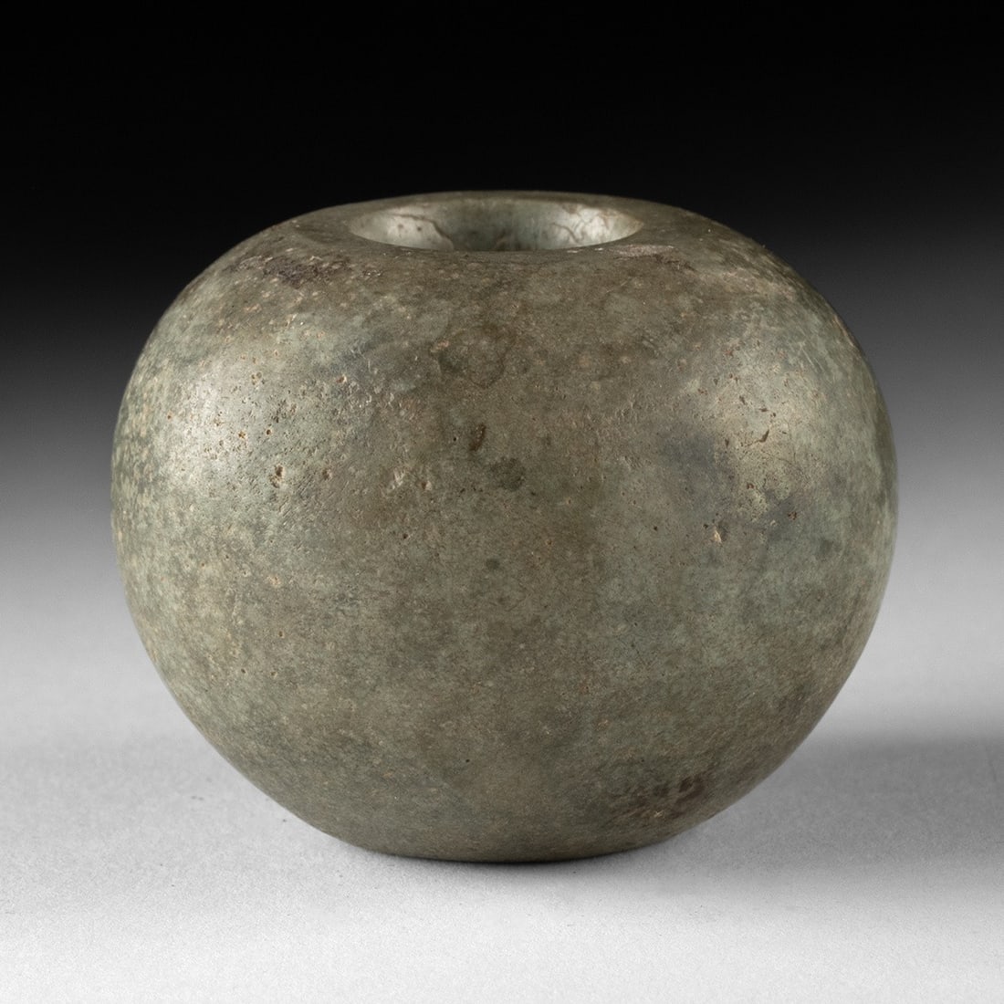 Egyptian Predynastic Green Stone Mace Head: North Africa, Egypt, Predynastic period, Naqada culture, ca. 4000–3100 BCE. A weapon reduced to pure geometry: a squat sphere of mottled green stone, its equator broadly swollen and its poles fl