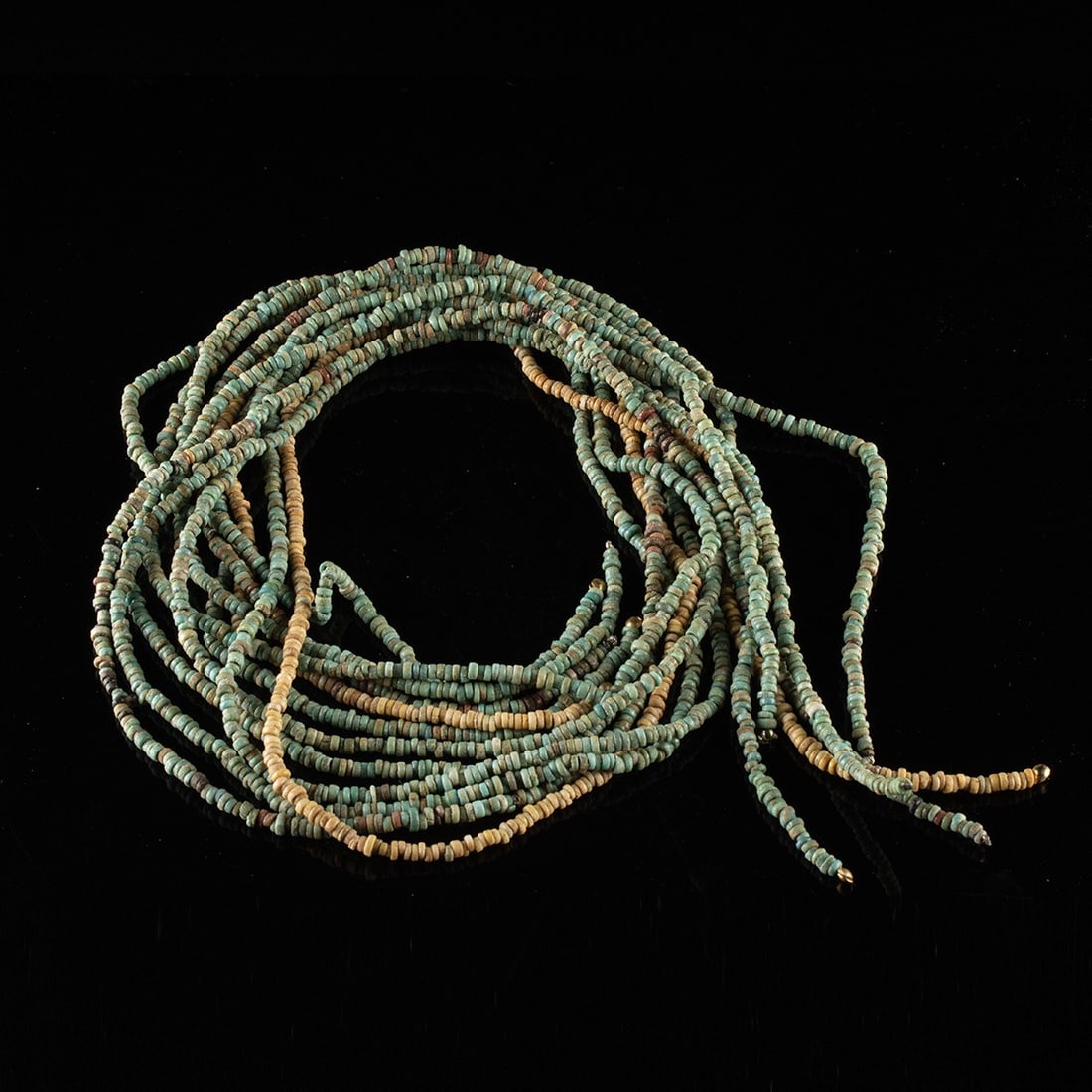 Six Egyptian Faience Mummy Bead Strands: Egypt, Late Dynastic to Roman period, ca. 664 BCE – 395 CE. A shoal of ancient faience discs, thousands of them, restrung into six long strands that shift from pale turquoise and sea green throu