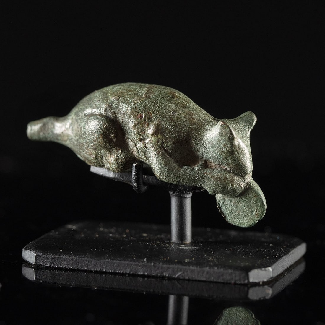 Roman Bronze Mouse Figure Nibbling Food: Roman, Imperial period, ca. 100–300 CE. A leaded bronze mouse, no bigger than a thumb joint, sits back on its haunches and lifts a rounded morsel of food to its mouth with both forepaws. The mod