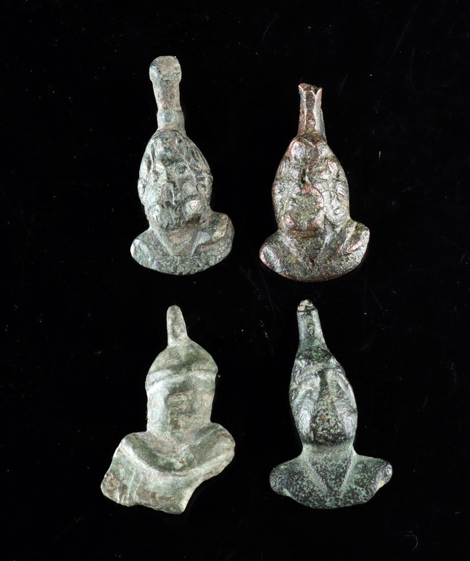 Roman Leaded Bronze Steelyard Weights - Group of Four Busts: Roman, Imperial period, ca. 100–300 CE. A quartet of cast leaded-bronze counterweights, each modeled as a small human bust rising from a rounded, lead-filled body that gave the piece its calibra