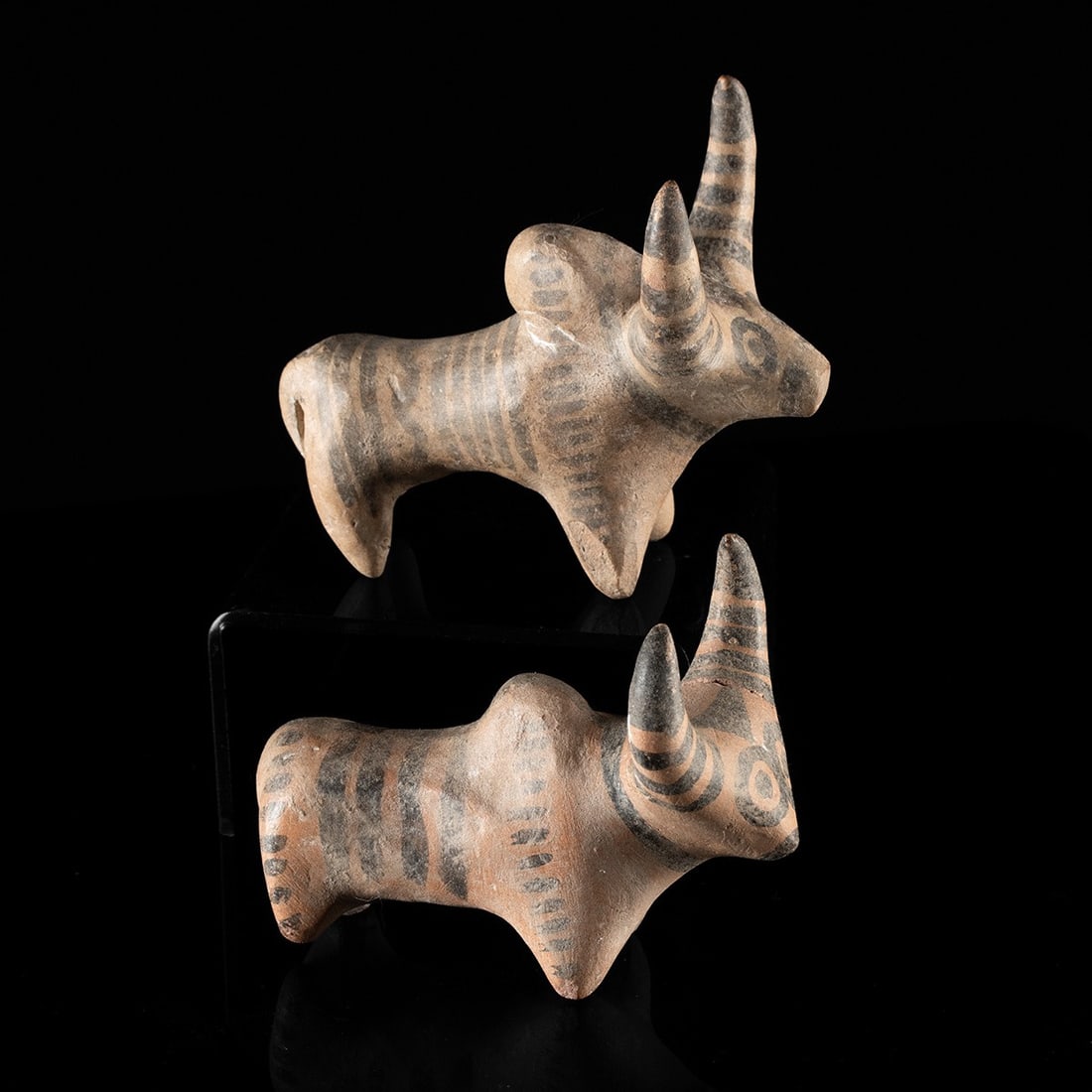 Two Indus Valley Painted Terracotta Zebu Bulls: Central Asia, Indus Valley, Harappan civilization, ca. 2700–2000 BCE. A pair of humped zebu bulls modeled in buff terracotta, each standing four-square on stub legs with a heavy dewlap swinging 