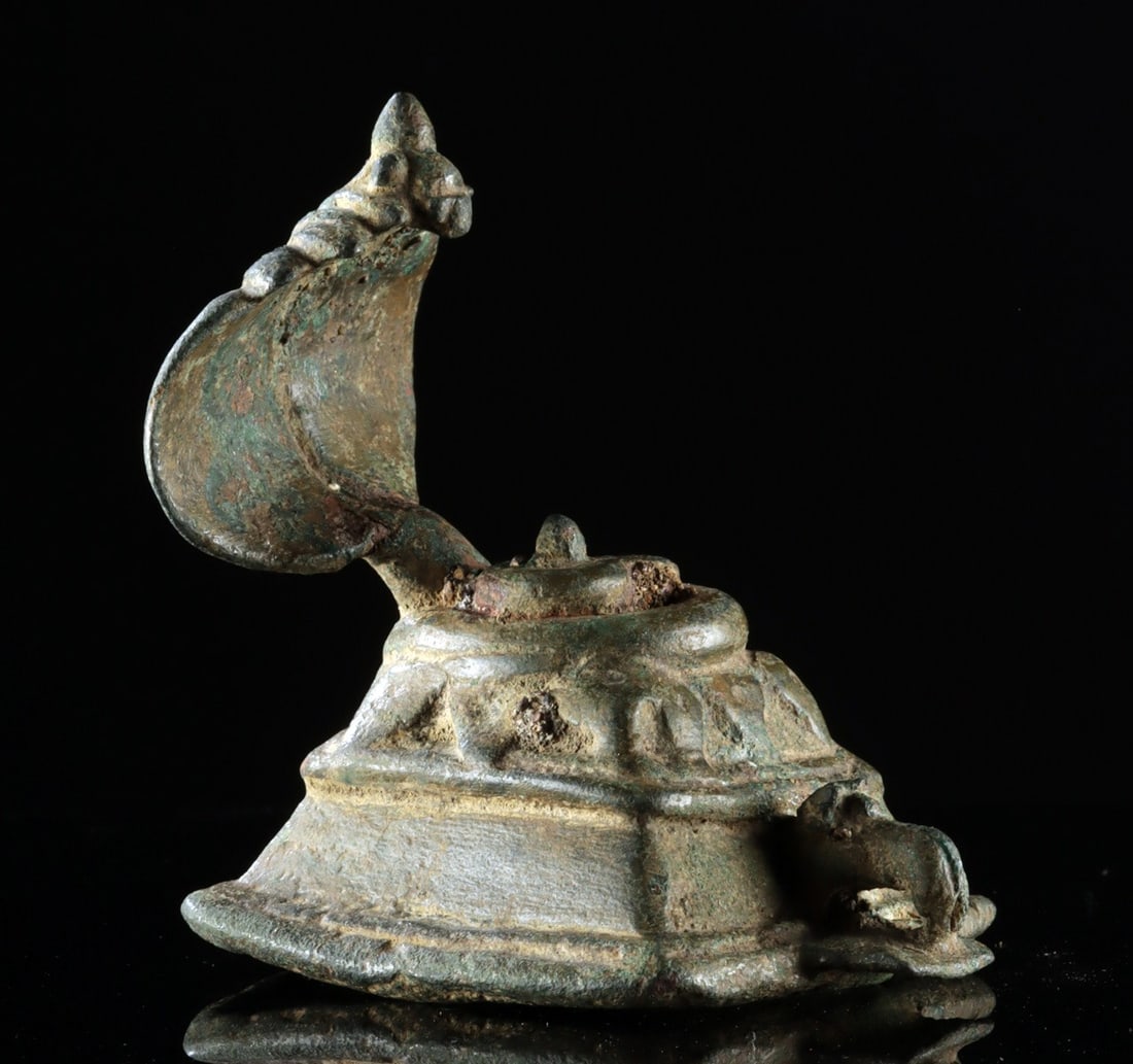 15th C. Indian Bronze Lingam With Naga: Ca. 1400–1500 CE. South Asia, India, ca. 15th century CE. A finely cast leaded bronze lingam, the sacred emblem of Shiva, rising from a square base and crowned by a protective naga serpent. The 