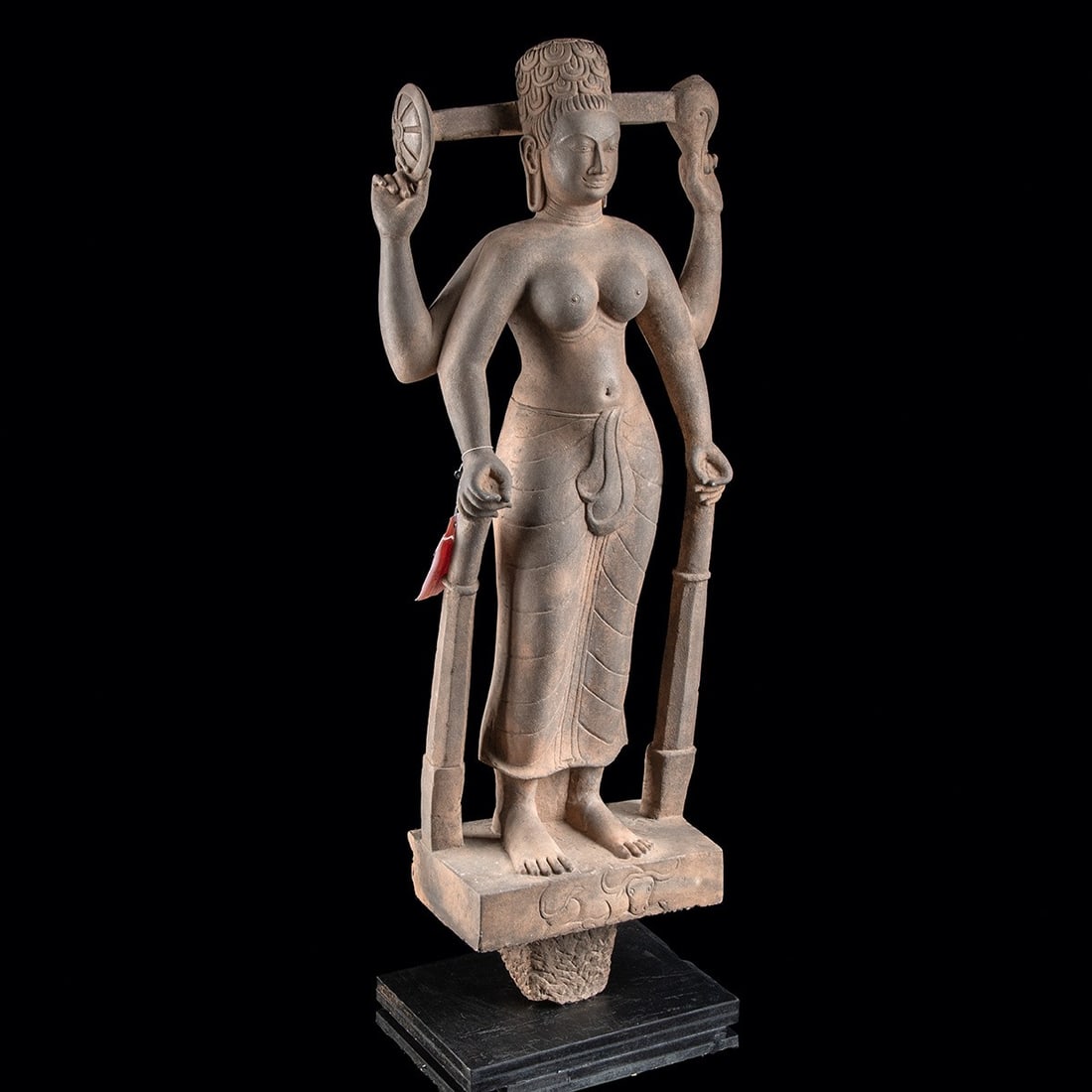 20th C. Cambodian Sandstone Durga - Mahishasuramardini, Slayer of Buffalo Demon: Southeast Asia, Cambodia, Khmer revival, ca. 1900–1970 CE. A four-armed goddess rises serene above the very demon she has slain, the water buffalo Mahisha couchant at her feet, his swept horns a
