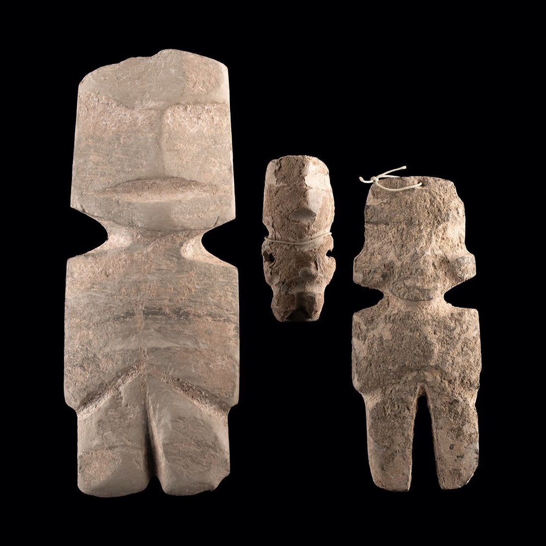 Pre-Columbian Mezcala Stone Effigy Figures, Group of Three: Pre-Columbian, Mexico, Mezcala, ca. 500 BCE – 300 CE. A group of three carved stone anthropomorphic figures in the classic Mezcala style, each reducing the human form to geometric planes with no