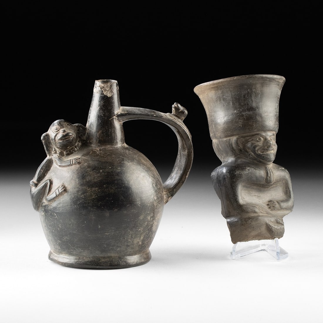 Chimu Blackware Vessels - Seated Figure Cup & Stirrup Spout Monkey Jar: Pre-Columbian, Peru, Chimu, ca. 900–1470 CE. A blackware vessel pair comprising a spouted jar and a figural cup. The jar has a globular body with a tapered cylindrical spout, an arching strap ha