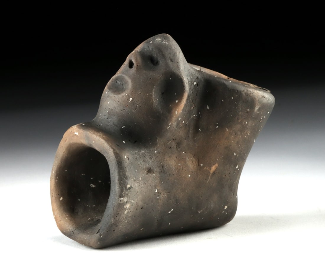Mississippian Blackware Effigy Pipe - Zoomorphic Figure: Native American, Mississippian culture, ca. 1000–1500 CE. A modeled ceramic smoking pipe whose burnished dark surface coalesces into the head of a stylized animal, its rounded muzzle, drilled ey