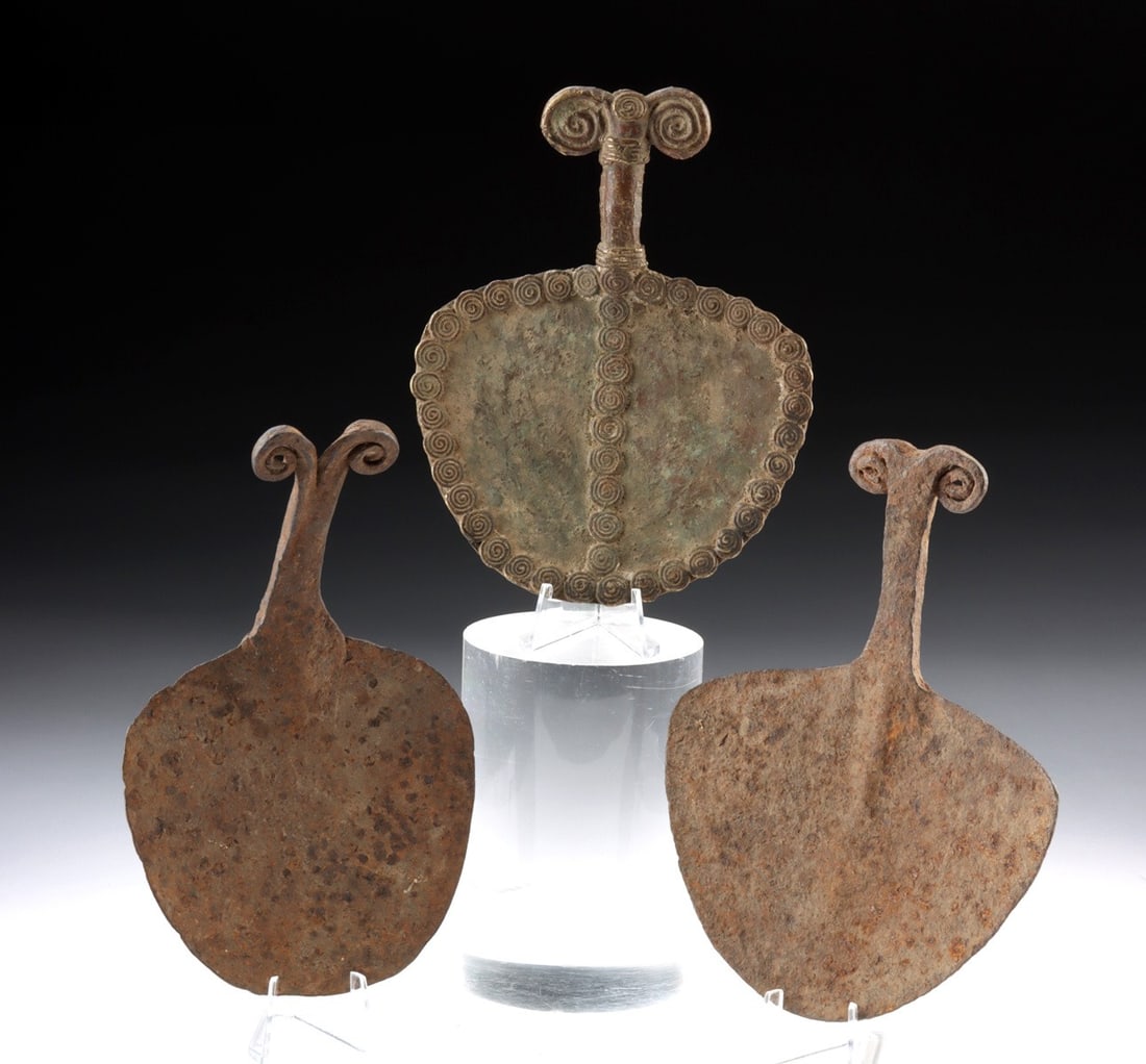 Three West African Chamba Iron & Copper Currency Blades: West Africa, Nigeria-Cameroon borderlands, Chamba people,, ca. 19th tot mid-20th century CE. A group of three hoe-form currency pieces, each with a broad fan-shaped blade and a slender neck surmounted