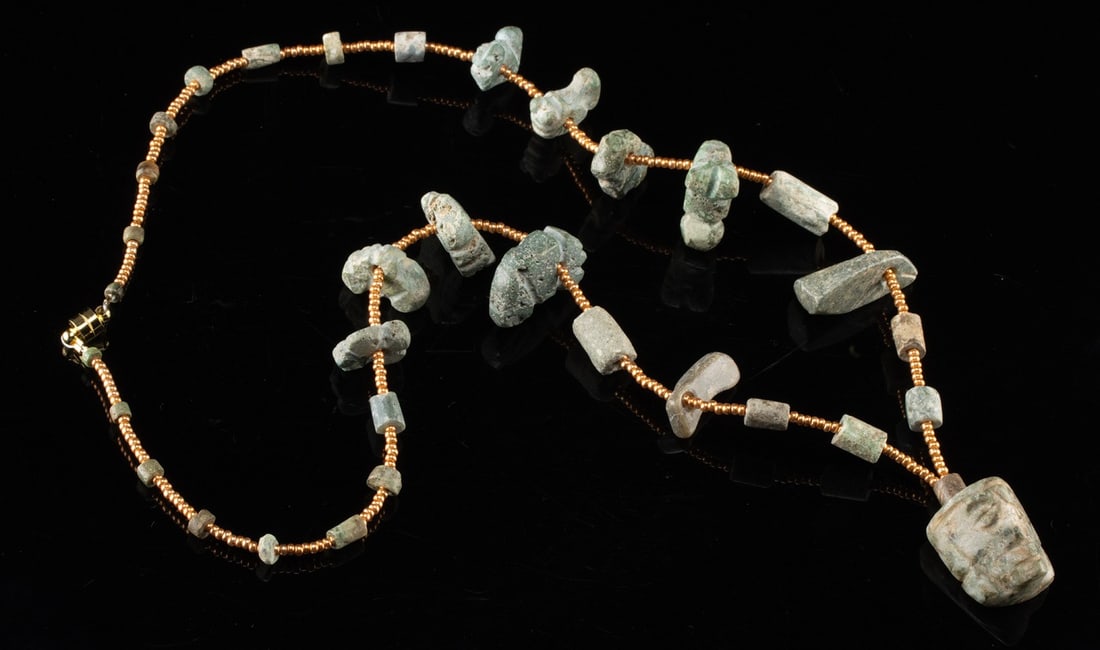 Mesoamerican Greenstone Bead Necklace + Face Pendant: Ca. 600 BCE – 900 CE. Pre-Columbian, Southern Mexico, Guerrero region, Mezcala to Maya culture, ca. 600 BCE to 900 CE. An ancient greenstone and jadeite bead necklace assembled as a wearable strand.