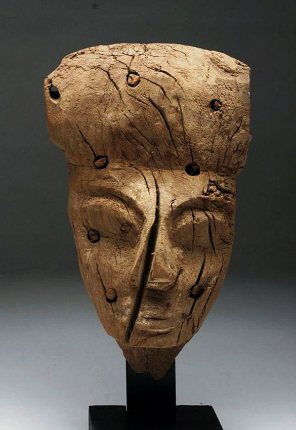 Egyptian Carved Wood Mummy Mask: Egypt, Late Dynastic Period, ca. 650 to 300 BCE. Mask made of cedar, carved into the form of a human face; once colored with vibrant pigments, now lost with time. Seven wooden dowels used to attach ma