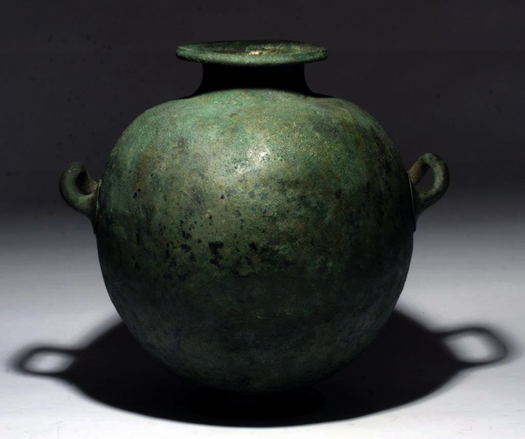 Exceptional Greek Bronze Hydria: Greece, ca. 5th - 4th century BCE. A large cast bronze amphora type vessel with three applied handles, low foot, and flat rim. The large ovoid body rests on an applied foot, with a tapering neck and f