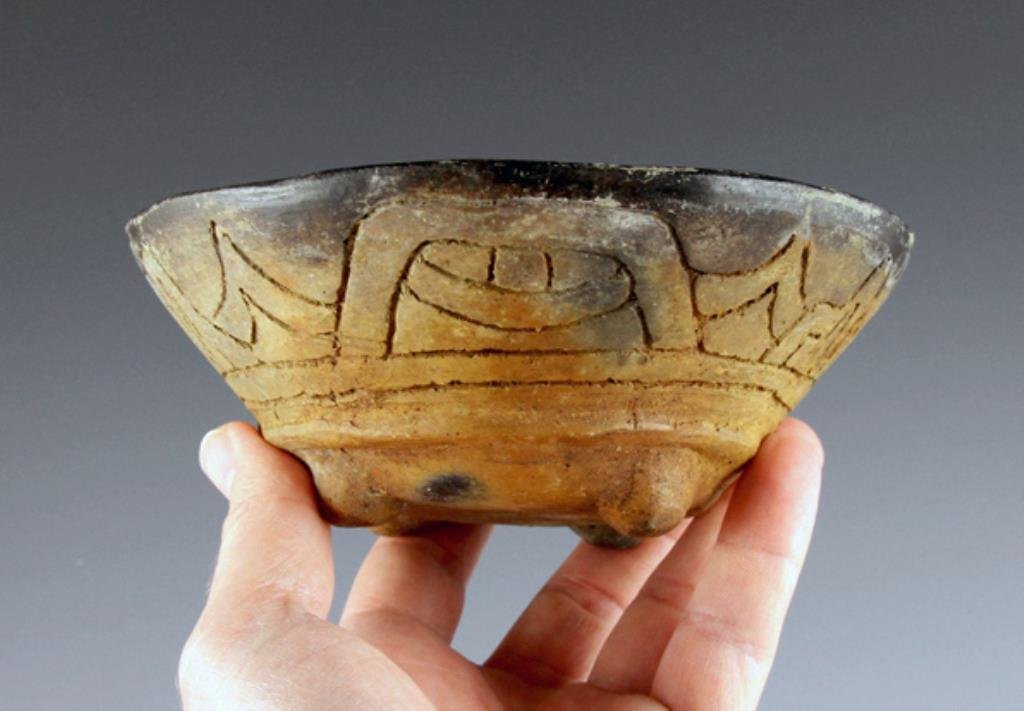 Pre-Columbian Bowl w/ Reptilian Eye: From ancient West Mexico, ca. 200 BCE - 200 CE. The form is that of a bowl sitting atop four nubbin feet. The interior features crosshatched, incised grating, and the exterior features incised decorat