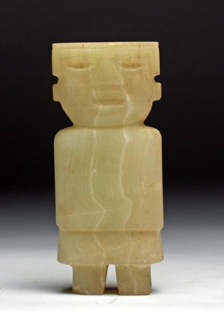Teotihuacan Carved Alabaster Figure: Pre-Columbian, Mexico, Ca 300 to 600 CE. Carved human figure of creamy alabaster with squared features, oval eyes and mouth, wearing long tunic and skirt, squared legs emerging beneath. 5-3/8" H x2-3/