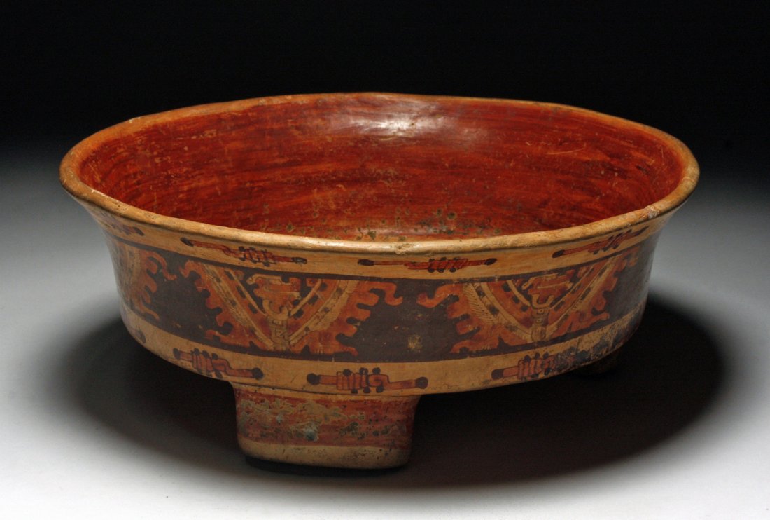 Mayan Polychrome Bowl with Tripod Rattle Feet: Honduras, Alua Valley, ca. 550-850 CE. Three magnicent Mayan turkey vultures, elaborately designed with red stripes and curvilinear forms are painted in red and orange slip on a deep brown ground on t