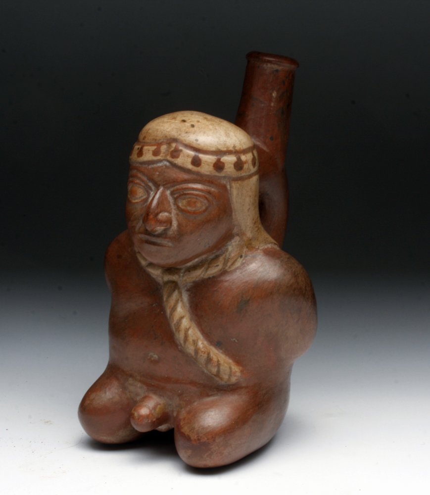 Moche Captive Spouted Vessel: Northern Peru, ca. 100CE, Moche I, Pre-Columbian. This redware pottery spouted vessel is in the form of a captive of warfare. Of paramount concern for Moche artists was their intention to inform and c