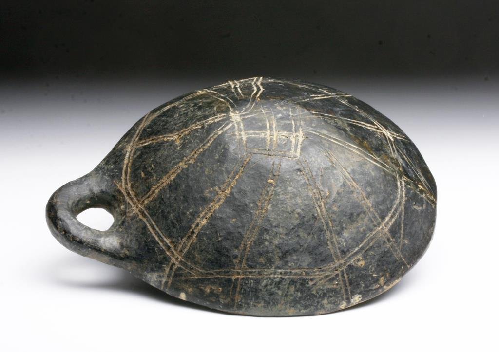 Anatolian Yortan Incised Dipper: Anatolia, Modern Day Turkey, ca. 2500 BCE. A terracotta blackware dish with small handle. Bottom of the bowl is decorated with double lined linear design. 5-1/4"W x 6-1/2"L. Provenance: Ex-Prominent N