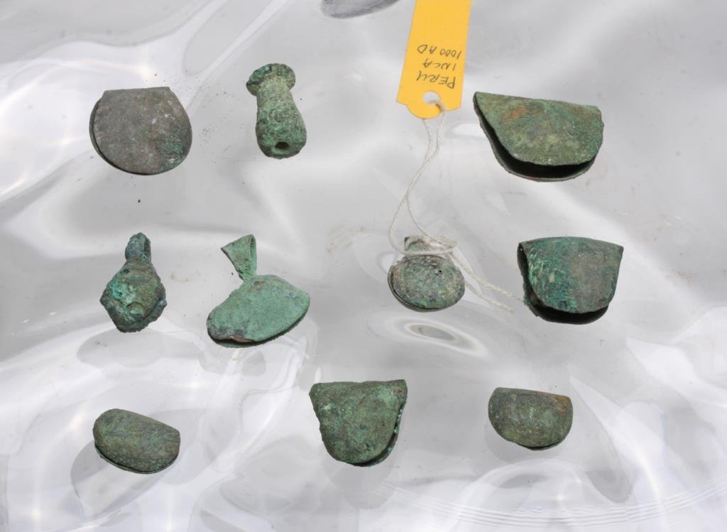 Ancient Peruvian Copper Artifacts Group Lot: Peruvian, likely Inca, ca. 1000-1500 CE. Group lot of ancient Peruvian copper pieces including seven hammered copper bells, one pendant bell, one teardrop-shaped pendant, and one olla-shaped bead. Ran
