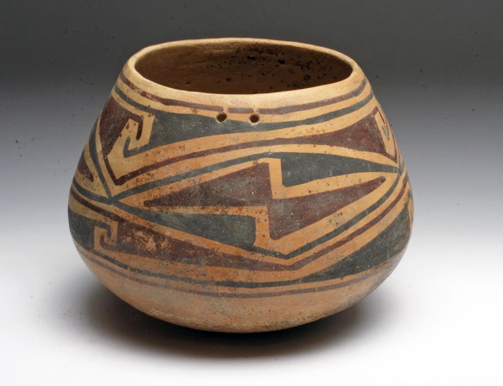 Casas Grande Olla: Northern Mexico, Ca 1300 CE. Nice example of authentic Casas! Bulbous-bottomed olla in orange pottery painted with red and black abstract decorations. Two suspension holes on each side. 6-3/4" D x 5-1