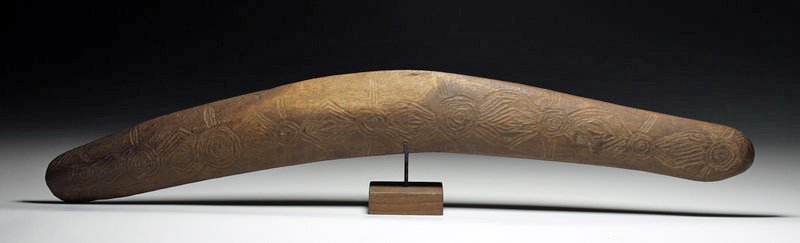 Aboriginal Australian Carved Wood Boomerang: Australia, end of 19th / first decade of 20th century CE. A large and superbly decorated boomerang (or throwing stick as this one was not designed to return on its own) of heavy hardwood, carved on ea