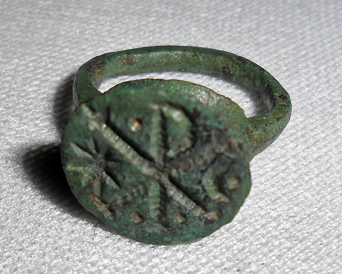Byzantine Bronze Signet Ring: Near East, ca. 600-900 CE. Small Byzantine bronze signet ring with 6 raised geometric circles and lines. Size 6. Provenance: found in Bethlehem in 1991. All items in this auction have been legally acq