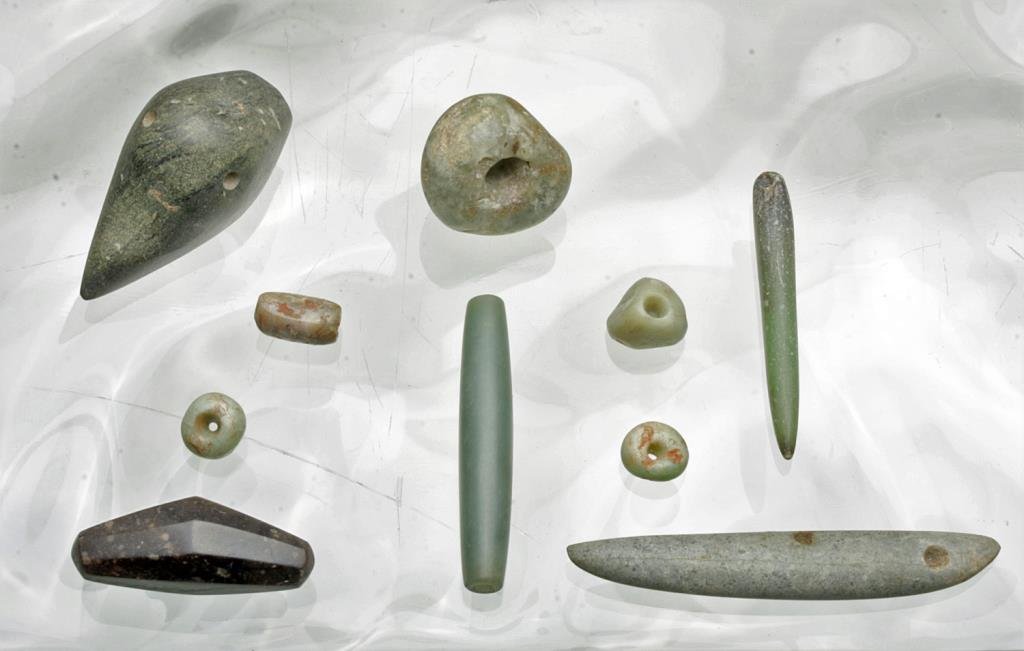 Lot of Pre-Columbian Jade and Stone Beads: Pre-Columbian, Costa Rica and Guerrero, Mexico, pre-1500 CE. This jade and rich stone lot includes ten beads of various shapes including round, tubular, tapered long pointed pieces that hang laterally