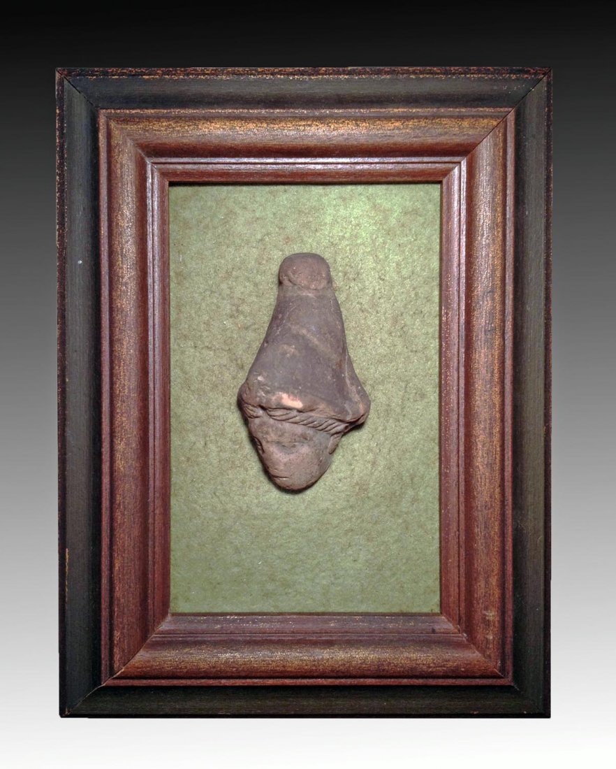 Framed Greco-Egyptian Head of a Woman: Egypt, ca. 400 - 300 BCE. Ancient head of a woman with an elaborate hat and showing curled hair under hat. Framed on a green felt background. 6 1/2"x 8 1/2" for frame. From an early Greek colony in Eg