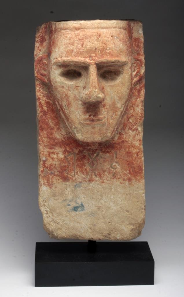 South Arabian Limestone Stele: Yemen, ca. 2nd century BCE - 2nd century CE. A wonderful painted limestone dedication stele, depicting a man with stylized beard, and strong forehead, nose and chin. Hollow eyes once contained preciou
