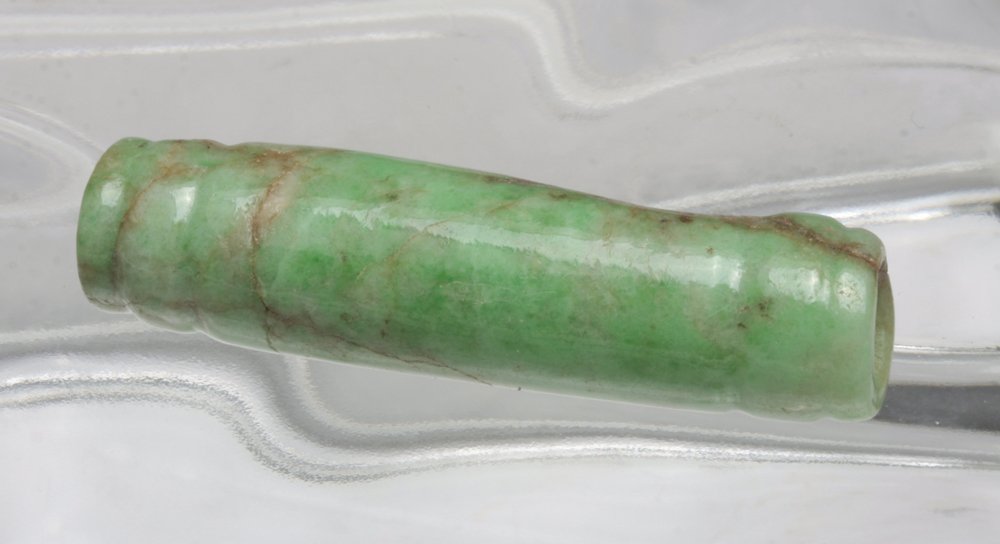 Stunning Mayan Apple Green Jade Bead: Pre-Columbian, Guatemala, Mayan To the indigenous of the ancient Americas, jade was a stone that carried powerful symbolism. Jade ornaments were used in ceremonial rituals and as adornments for the el