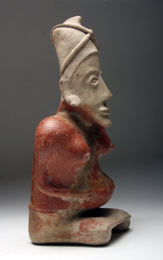 Jalisco Seated Heavily Pregnant Female Figure: Pre-Columbian, Mexico, ca. 500 BCE -500 CE. Terracotta figure of a seated woman with enlarged breasts and extended belly indicating pregnancy. Stone polished surface. 14"H x 7"W. Provenance: Ex-Jules 