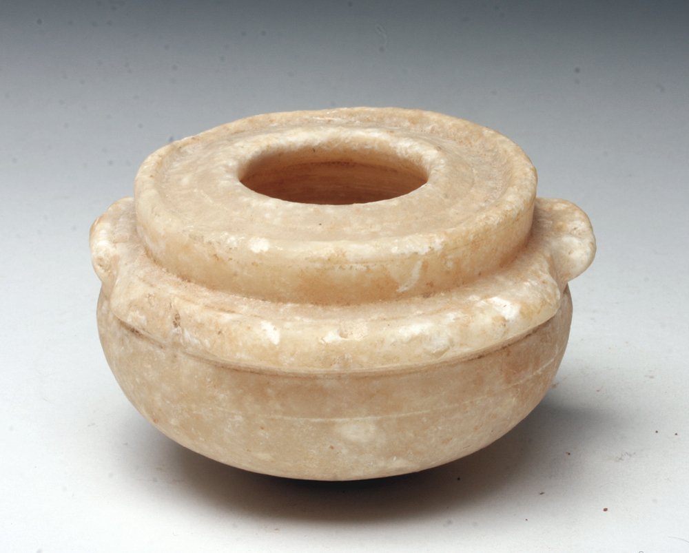 Bactrian Alabaster Storage Jar, Ex-Christie's: Pakistan / Afghanistan, Bactrian culture, Ca 1000 to 500 BCE. Carved alabaster jar with flat rim and two small lug handles, pierced for suspension. 3" in diameter. Provenance: Ex-private NYC Collecti