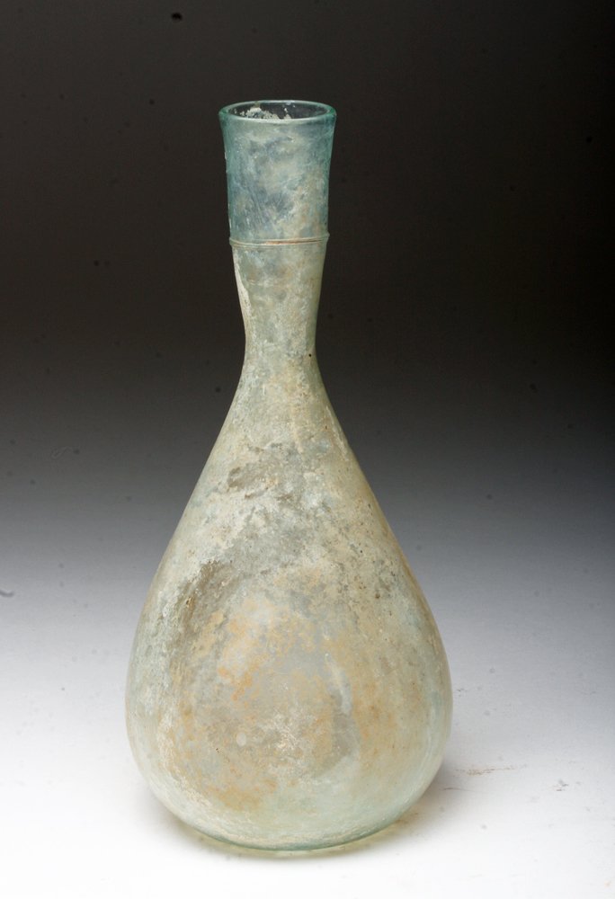 Large Roman Glass Vessel: Roman Empire, Ca 200 to 350 CE. Nearly clear colored glass bottle with bulbous base and long tapered neck, small band of added threads added. 6-1/2"H. Provenance: Ex-private Florida Collection, acqui
