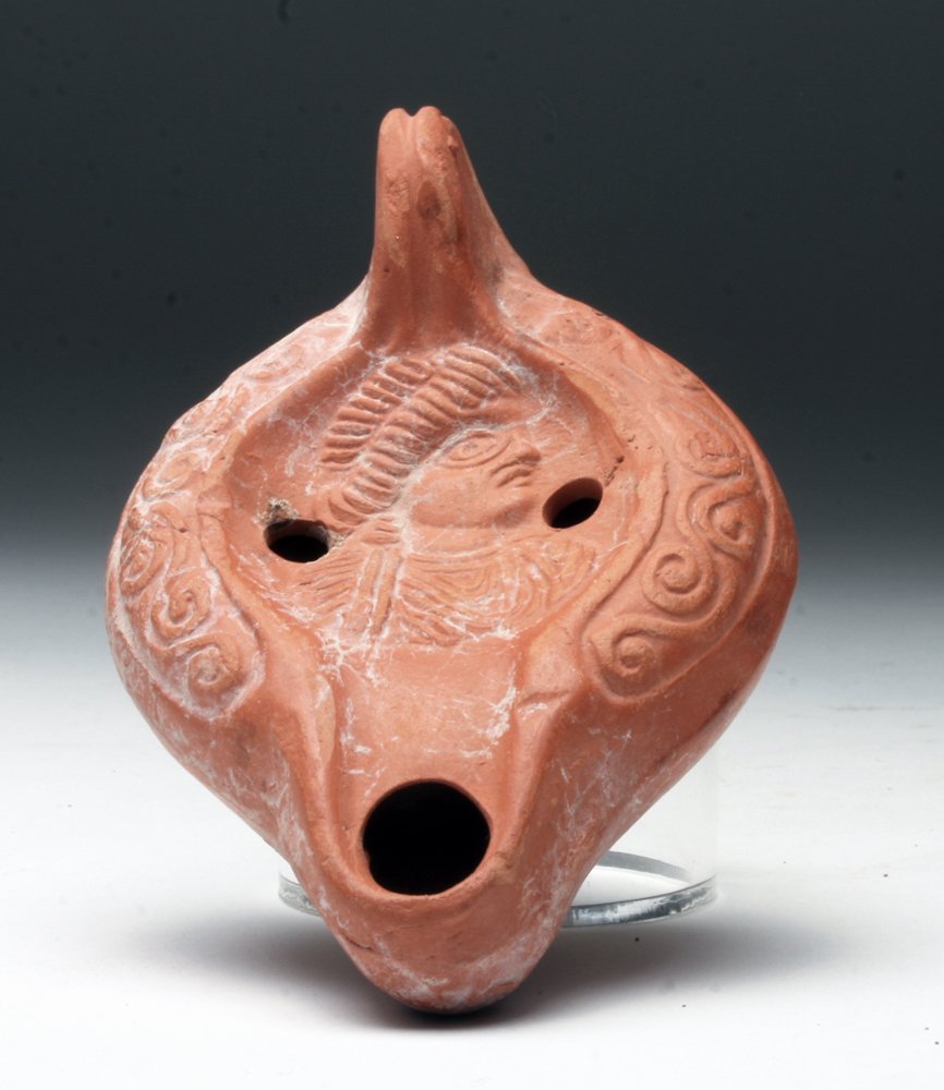 Roman Redware Lamp, Maker's Mark: North Africa, Roman Empire, Ca 400 CE. Redware pottery lamp, decorated on discus with either soldier or current emperor dressed in military garb. Maker's mark on base in Greek letters. 4-3/8" L. Prove
