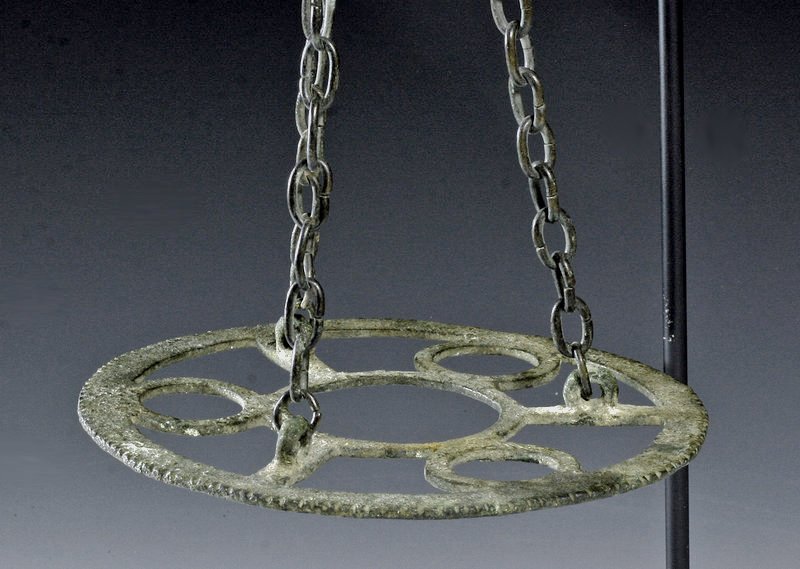 Byzantine Bronze Polycandelon: Byzantine Empire, ca. 500 CE. Solid bronze polycandelon with original chain. A beautiful open work design centered around a large open circle, with three circles and three bars surrounding it. Incised