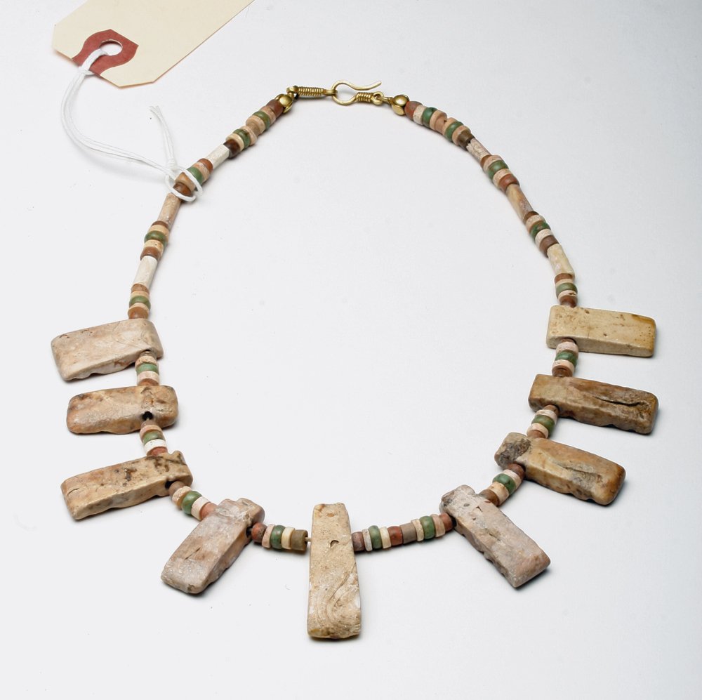 Colombian Shell and Stone Collar Necklace: Pre-Columbian, Colombia, ca. 100-1500 CE. This striking collar is comprised of nine large lozenge shaped, blond-hued beads hand-carved from shells and numerous smaller round and tubular stone and shel