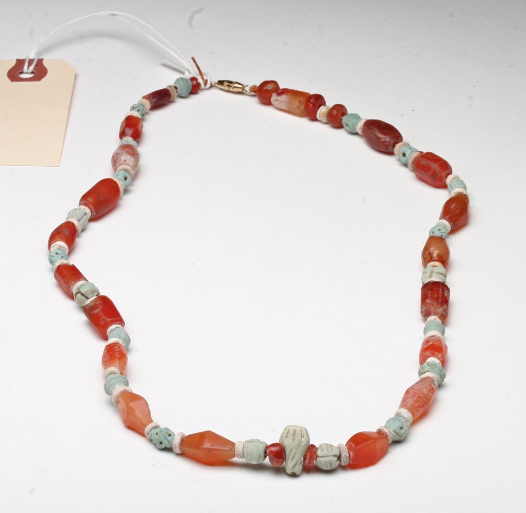 Romano Egyptian Faience / Carnelian Necklace: Egypt, Roman Period, ca. 1st century CE. A fine necklace composed of small carved faience and beautiful carnelian stone beads. Faience beads are carved with linear designs, several having both linear