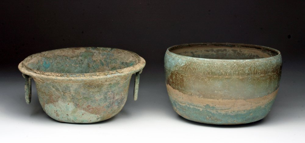 Lot of 2 Cambodian Offering Bowls: Cambodia, ca. 12th -14th Century CE. Two cast bronze bowls, one with ringed handles on each side, the other with incised design around body. Heavy patination on both. 8" & 8-3/4"D. Provenance: Ex-Smit