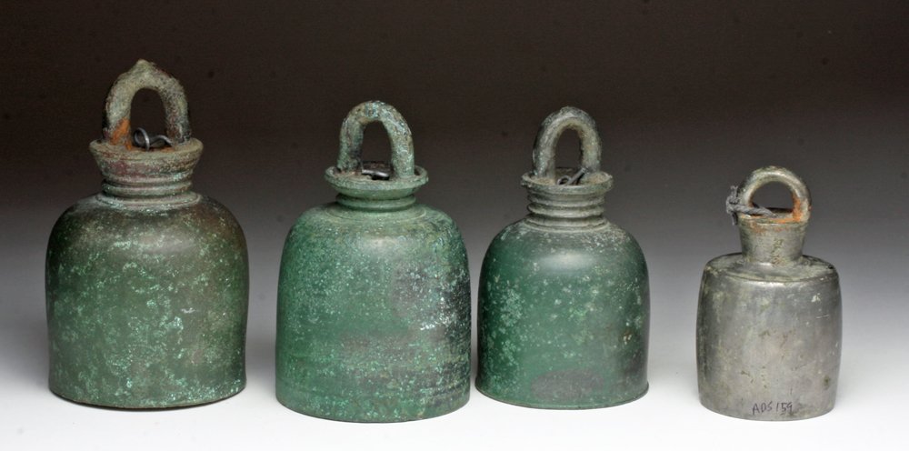Lot of 4 Khmer Bells - Bronze and Silver: Cambodia, Khmer Period, ca. 12th - 14th century CE. . A set of four domed belles, head with large mounting loops, likely used on cattle. All with center knocker preserved. All of bronze, save one whic
