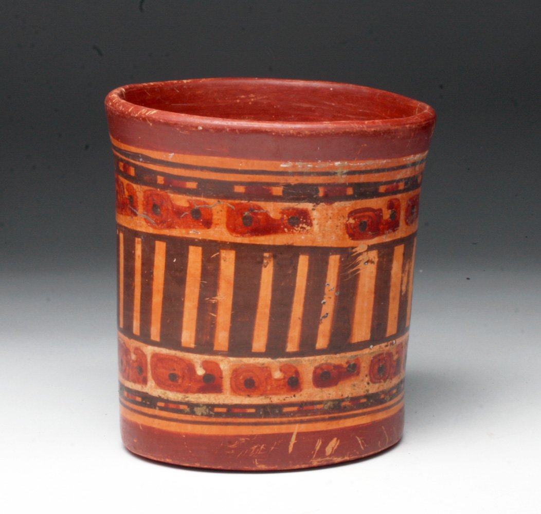 Pre-Columbian Mayan Polychrome Cylinder: Mayan Territories, most likely El Salvador or Honduras, ca 550 to 800 CE. Terracotta vessel - of the type most commonly used for drinking cocoa - decorated with vertical columns between glyphoids. 5-3