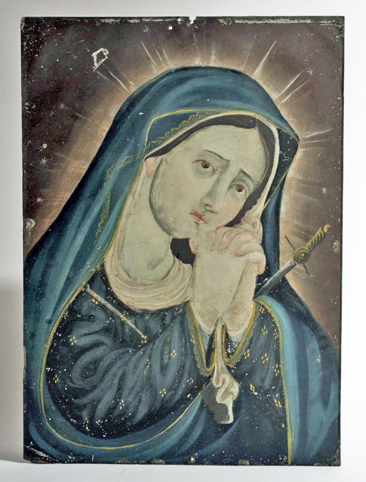 Antique Mexican Retablo, Mater Dolorosa: Mexico, ca. 19th Century CE. An antique tin painting depicting the Mater Dolorosa. This example depicts the mourning Holy Mother on the day of Crucifixion. She is shown in dark robes, with clasped han