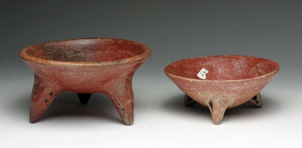 Lot of 2 Chupicuaro Redware Tripod Vessels: Pre-Columbian, Mexico, Guanajuato Valley, ca. 300-200 BCE. Pair of ceramic tripod legged bowls, both showing brilliant red hues, the larger boasting a band of red on cream geometric motifs circumambul