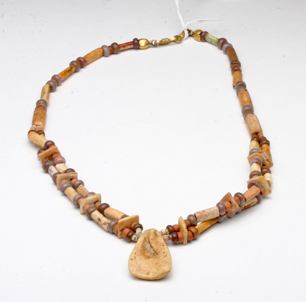 Tairona Shell and Stone Necklace: Pre-Columbian, Colombia, Tairona culture, ca 500-1500 CE. Necklace comprised of ancient tubular, lozenge and circular shaped stone and shell beads of varying cream and red hues. All are arranged in an
