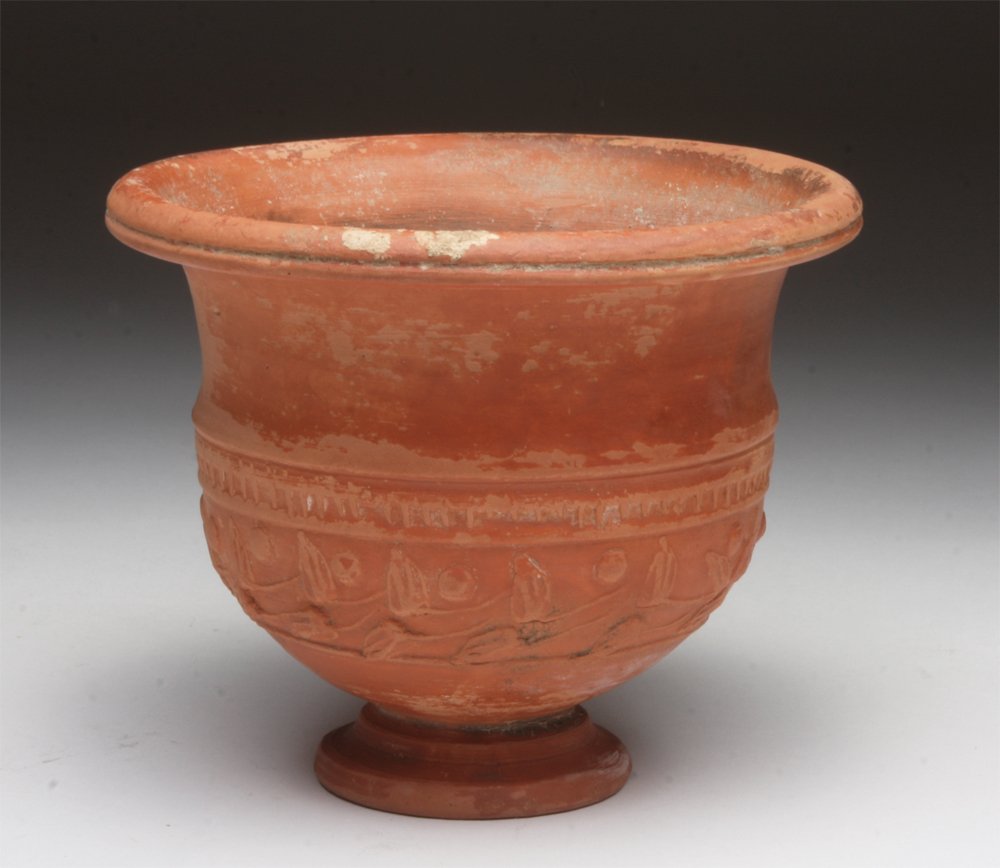 Roman Terra Sigillata Vase: Rome, ca. 1st - 3rd century CE. A well crafted redware pottery with pedestal and flared rim, and floral design in raised relief. 4-1/2"H x 5-3/4"D. Provenance: Ex-Private German Collection, acquired a