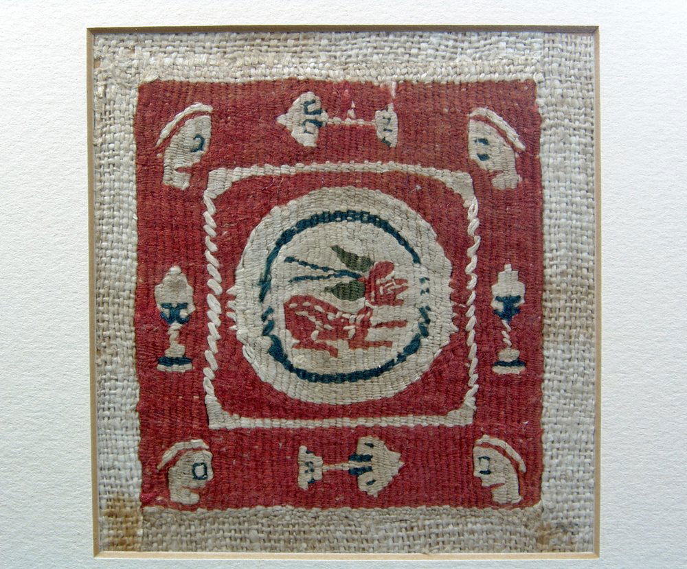 Framed Coptic Bi-Chrome Textile with Hare: Egypt, ca. 5th-7th Century CE. Ancient woven textile features bichrome medallion of a crouching hare rendered with spotted fur and green ears (the last looking much like an adhered butterfly). The cor