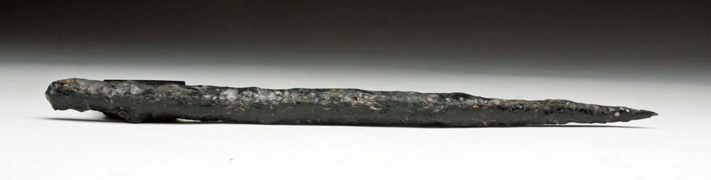 Deadly Colima Obsidian Stemmed Dagger: Pre-Columbian, West Mexico, Ca 200 BCE to 200 CE. A fine and once quite deadly obsidian dagger made from volcanic glass. Deep black and with hundreds of knapped flakes removed to create this deadly da